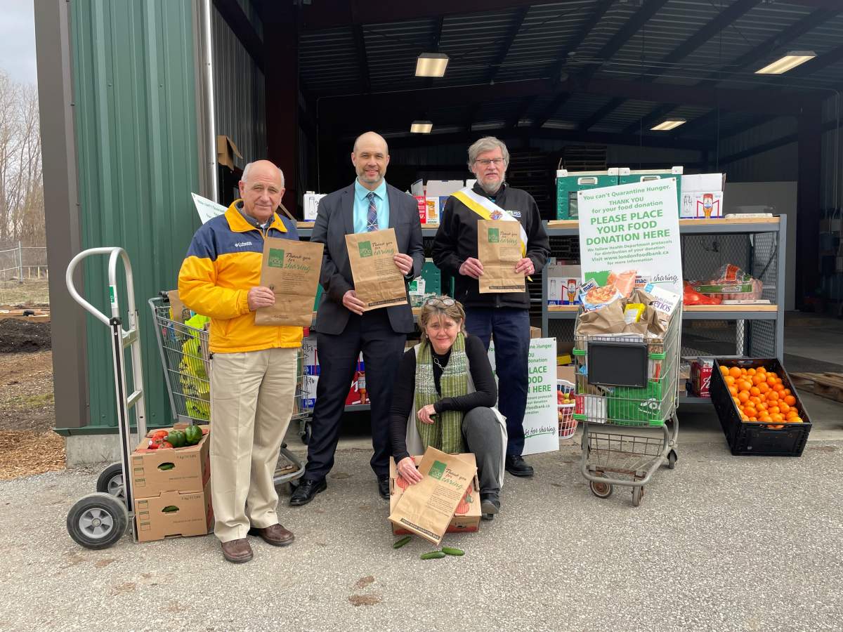 Glen Pearson, co-director of London Food Bank (left), David Billson, CEO and Co-Founder of rTraction (middle), Gary Masters, District Deputy, Knights of Columbus (right), and Jane Roy, co-director of London Food Bank (front) at the Spring Food Drive Launch.