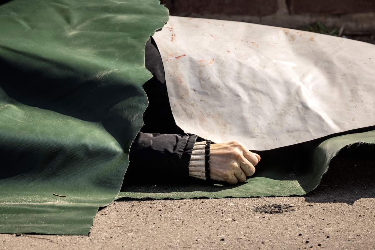 A body lies on the ground covered with plastic sheets after a rocket attack killed at least 35 people on April 8, 2022 at a train station in Kramatorsk, eastern Ukraine, that was being used for civilian evacuations.