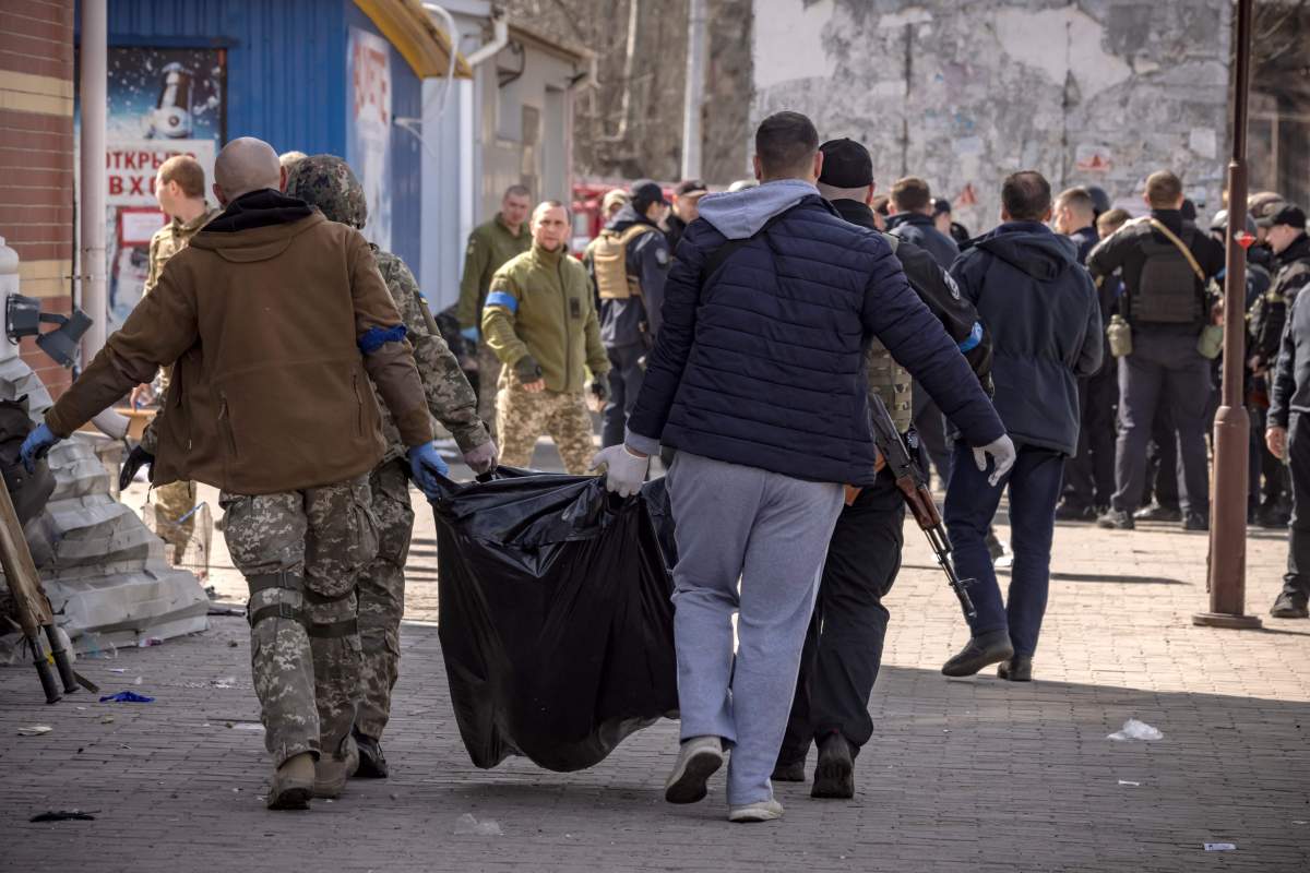 Ukrainian soldiers clear out bodies after a rocket attack killed at least 35 people on April 8, 2022 at a train station in Kramatorsk, eastern Ukraine, that was being used for civilian evacuations.