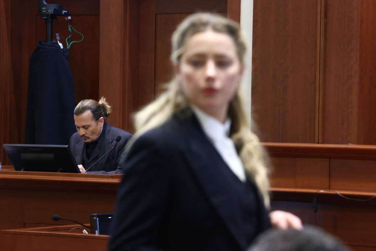 US actress Amber Heard (R) speaks to her legal team as US actor Johhny Depp (L) returns to the stand after a lunch recess during the 50 million US dollar Depp vs Heard defamation trial at the Fairfax County Circuit Court in Fairfax, Virginia, April 21, 2022.