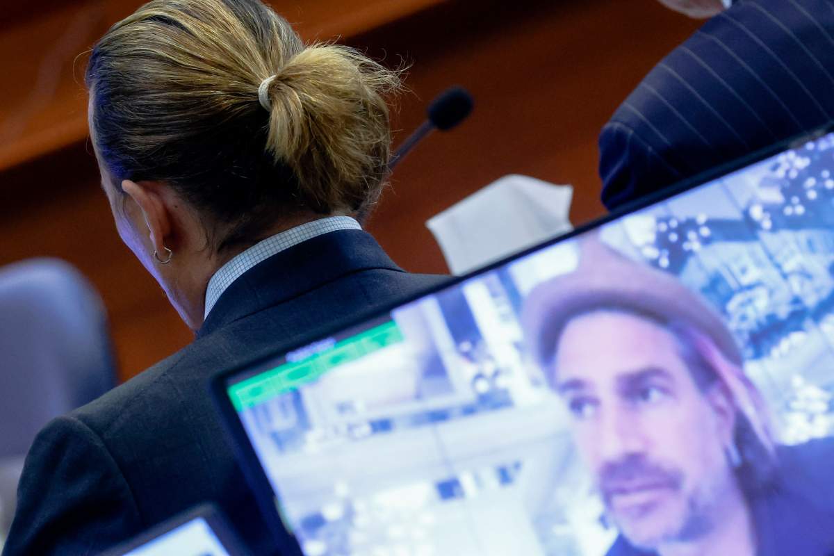 Actor Johnny Depp is seen as a pre-recorded deposition testimony of Christian Carino is played on screens during Depp's defamation trial against his ex-wife Amber Heard, at the Fairfax County Circuit Courthouse in Fairfax, Virginia, April 27, 2022.