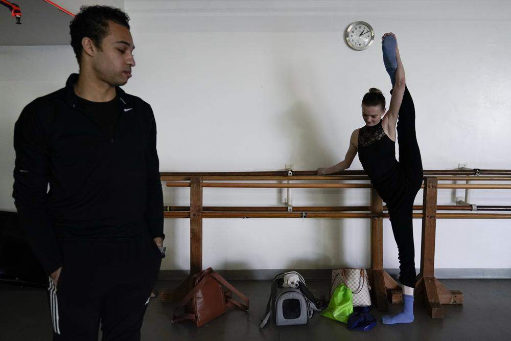 Adrian Blake Mitchell, left, and Andrea Laššáková warm up near their dog, Beau, before rehearsing on Monday, April 18, 2022, in Santa Monica, Calif. (AP Photo/Ashley Landis).
