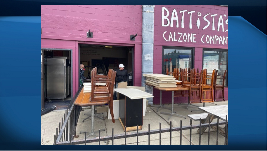 Workers help clean up Battista's Calzones after a fire.