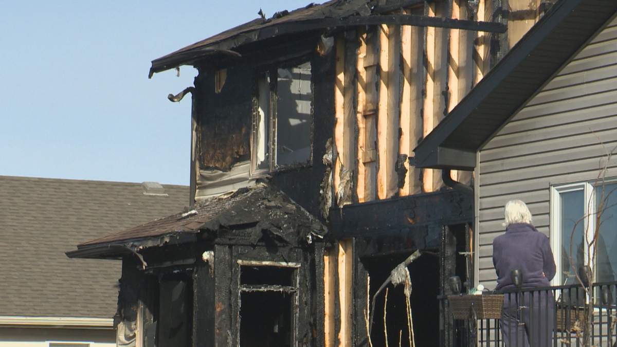 A neighbour surveys the damage after a fire ripped through a south Lethbridge home on Apr. 5, 2022.