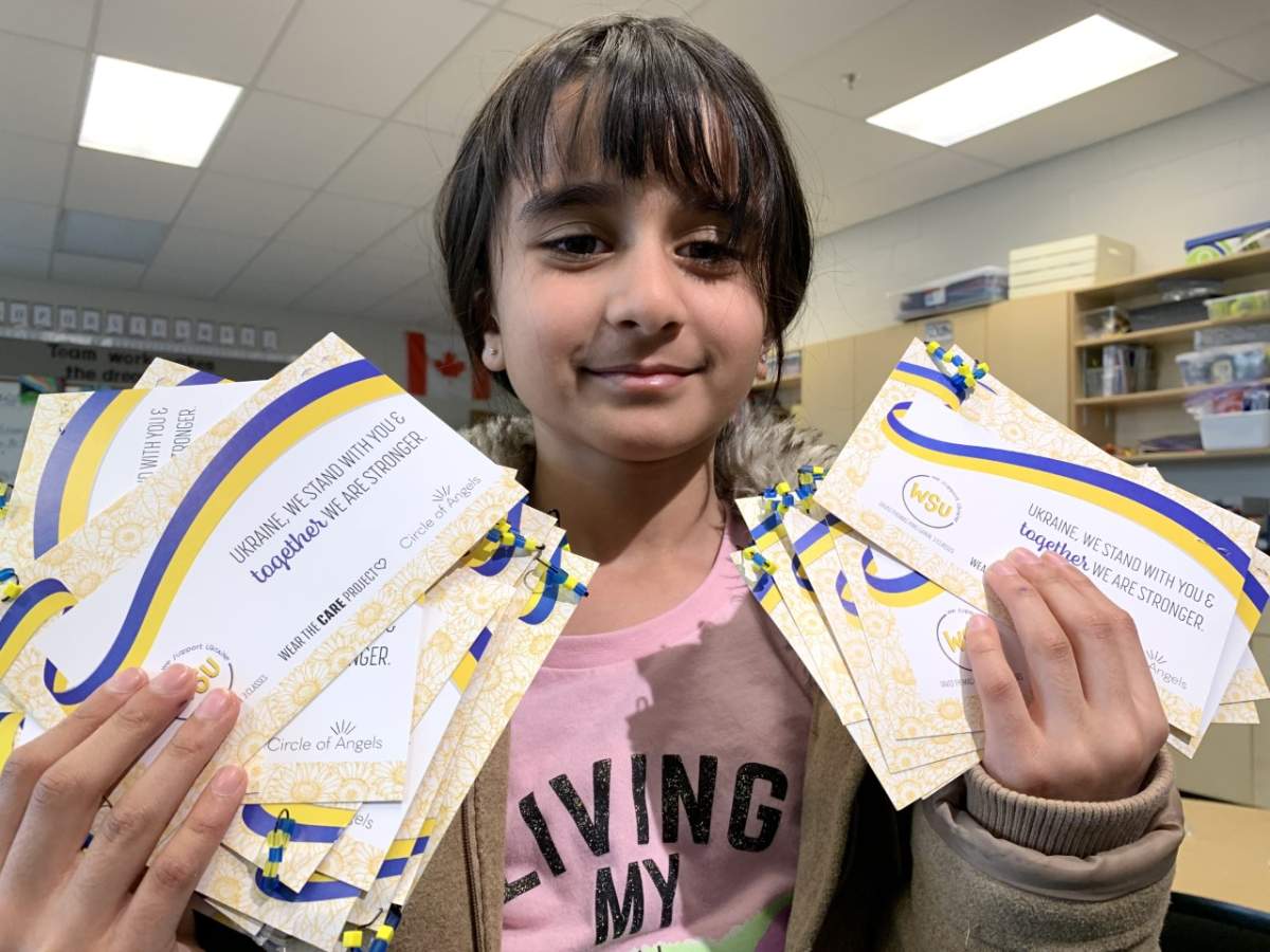 Emaan Ahsan, a Grade 3 student in Edmonton, poses with pins she made to help raise money for Ukraine.
