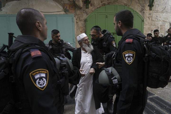 Israel police argues with a Palestinian worshipers the Old City of Jerusalem, Sunday, April 17, 2022.