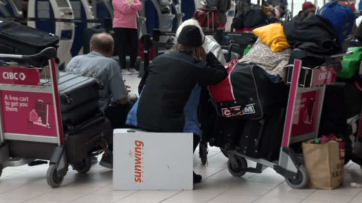 People are seen waiting at Pearson Airport on Monday.