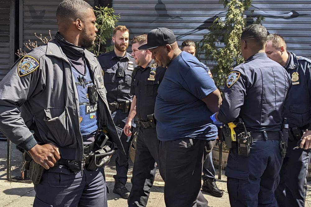 New York City Police Department officers handcuff subway shooting suspect Frank R. James