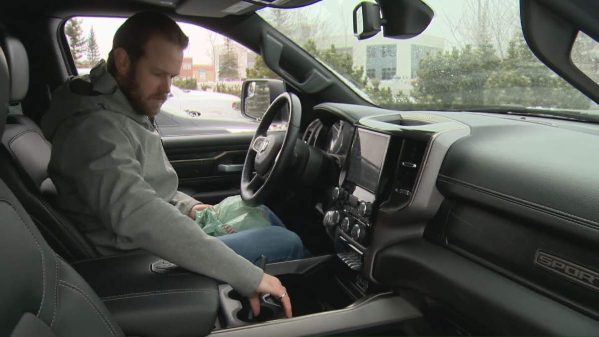 Jesse Waddell sits in truck as he waits for new vehicle to arrive