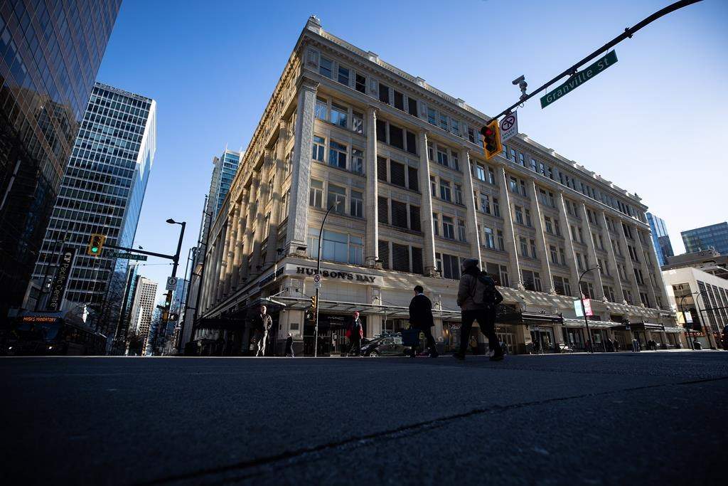 People cross the street in downtown Vancouver, on Wednesday, February 23, 2022.