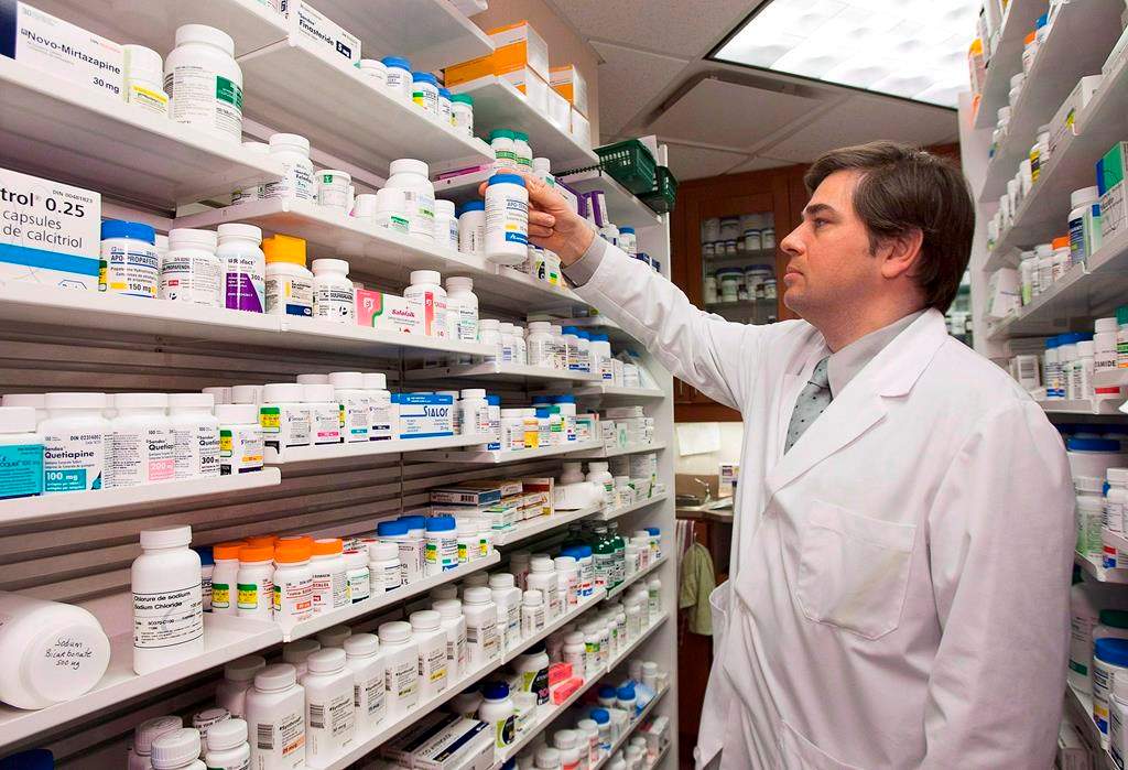Pharmacist Denis Boissinot checks a bottle on a shelf at his pharmacy on March 8, 2012 in Quebec City.