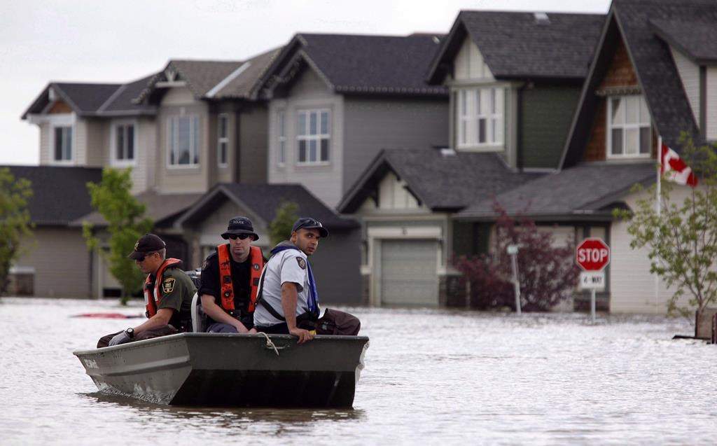 Members of the RCMP return from a boat patrol of a flooded neighbourhood in High River, Alta., on July 4, 2013.