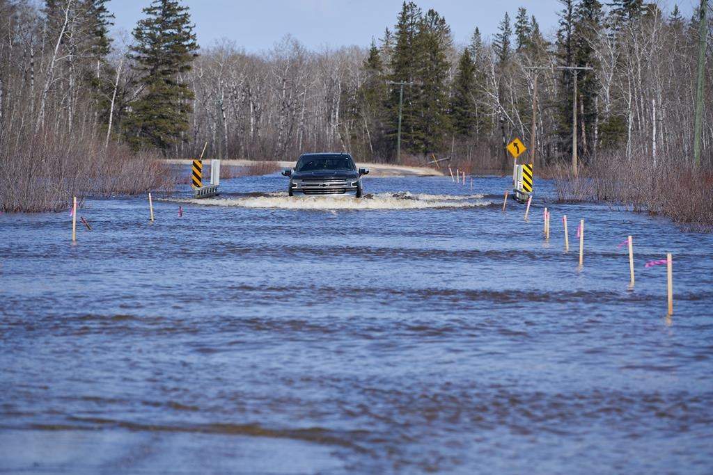 A truck navigates flood waters in Peguis First Nation, Man., Wednesday, May 4, 2022.