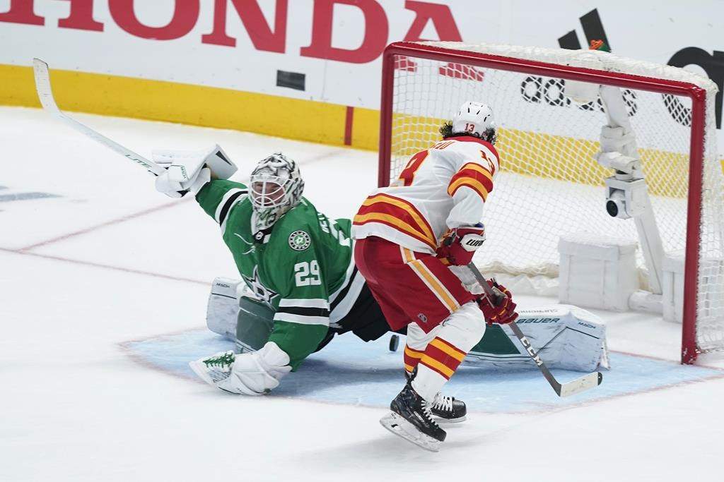 Calgary Flames left wing Johnny Gaudreau (13) scores on a penalty shot on Dallas Stars goaltender Jake Oettinger (29) in the third period of Game 4 of an NHL hockey Stanley Cup first-round playoff series, in Dallas, Monday, May 9, 2022. The flames even up their playoff series against the Stars at two wins apiece after their 4-1 win.