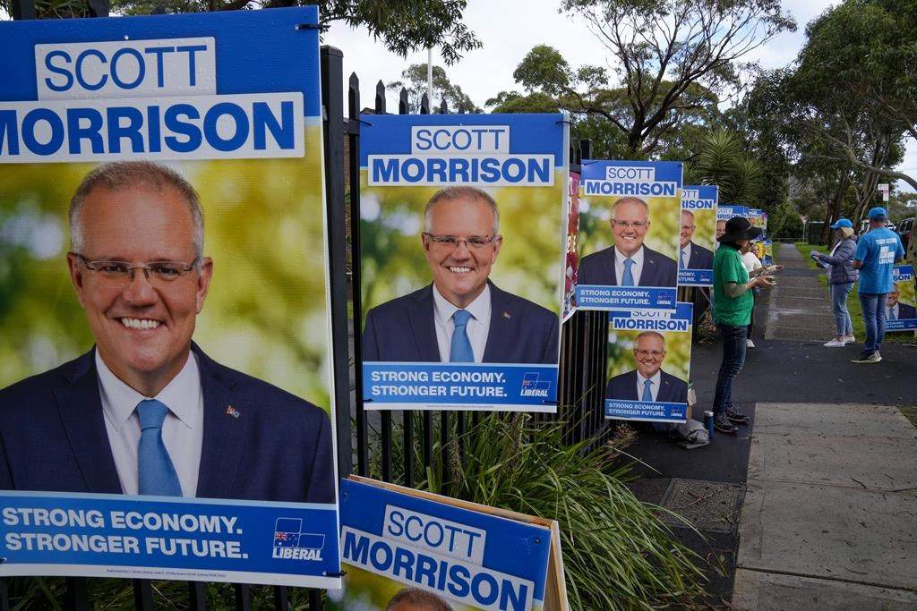 Volunteers stand outside a polling station as they wait for Australian Prime Minister to vote in Sydney, Australia, Saturday, May 21, 2022.