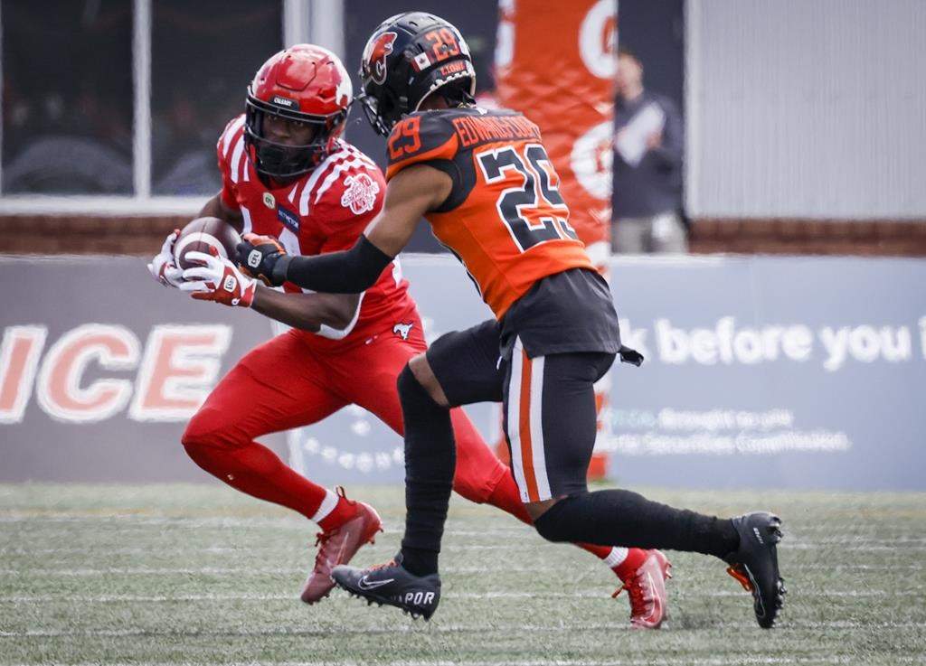 B.C. Lions' Jalon Edwards-Cooper, right, tackles Calgary Stampeders' Shawn Bane during first half CFL pre-season football action in Calgary, Alta., Saturday, May 28, 2022.