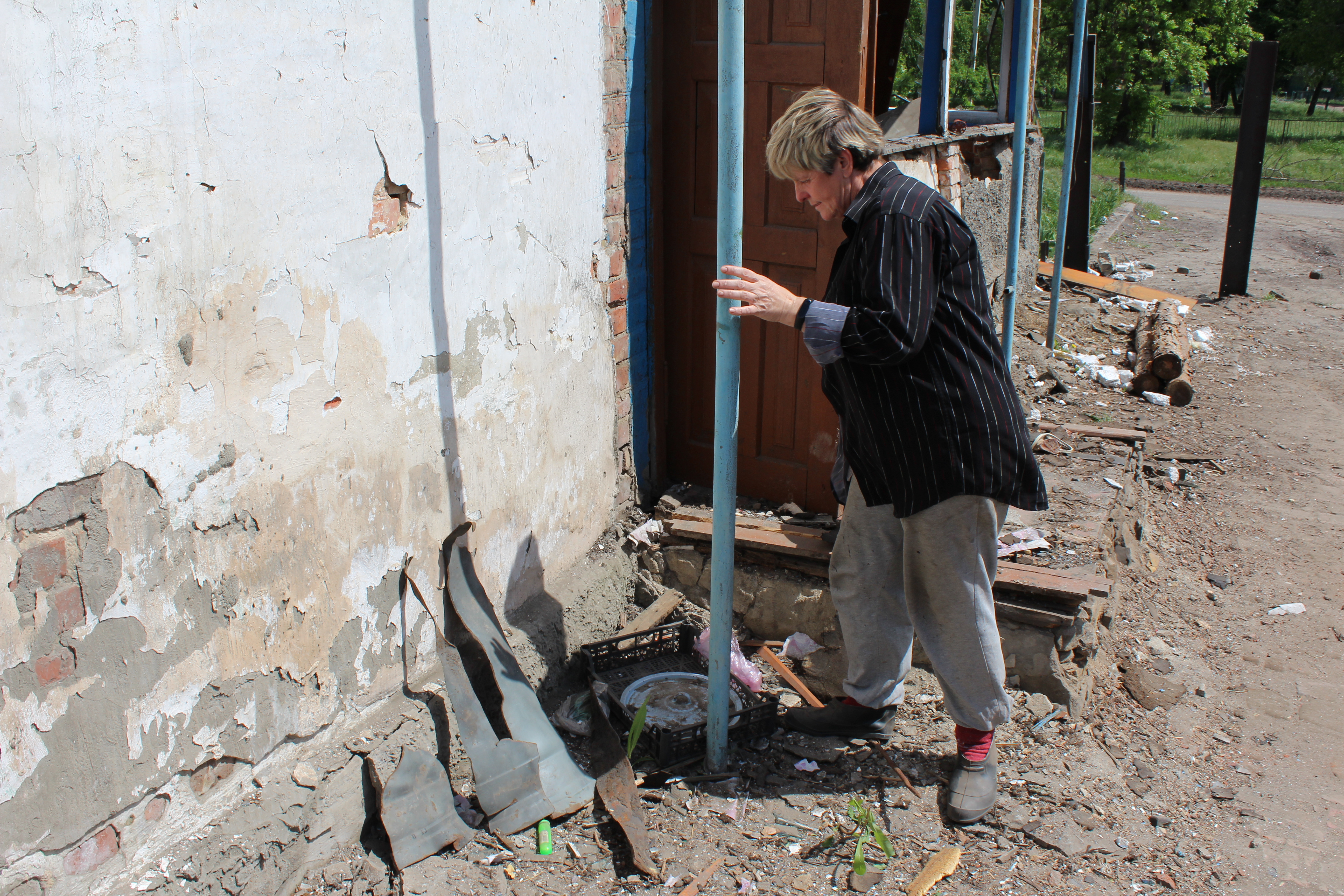 Resident of Barvinkove looks at fragments of Russian missile that struck her house, May 19, 2022.