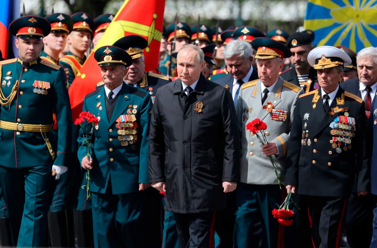 Russian President Vladimir Putin, centre, attends a wreath-laying ceremony at the Tomb of the Unknown Soldier after the military parade marking the 77th anniversary of the end of World War II, in Moscow, Russia, Monday, May 9, 2022.