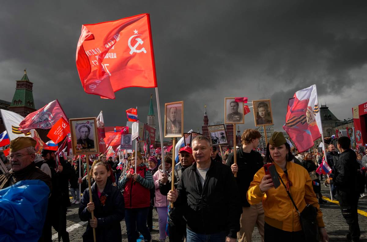 People attend the Immortal Regiment march through Red Square marking the 77th anniversary of the end of World War II, in Moscow, Russia, Monday, May 9, 2022.