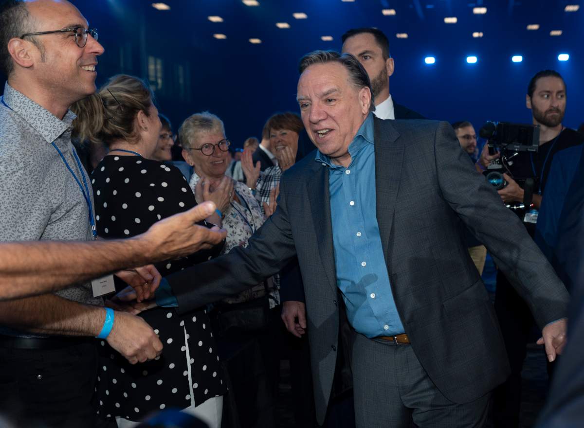 Quebec Premier François Legault shakes hand with delegates as he enters a Coalition Avenir Québec annual congress, in Drummondville, Que., Saturday, May 28, 2022.