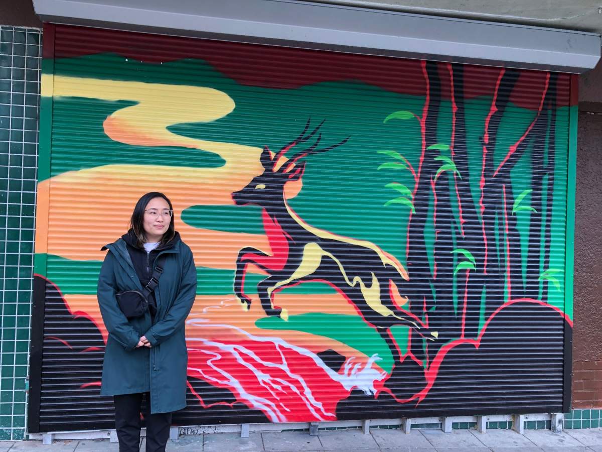 Artist Carolyn Wong stands with one of her murals in Vancouver’s historic Chinatown.