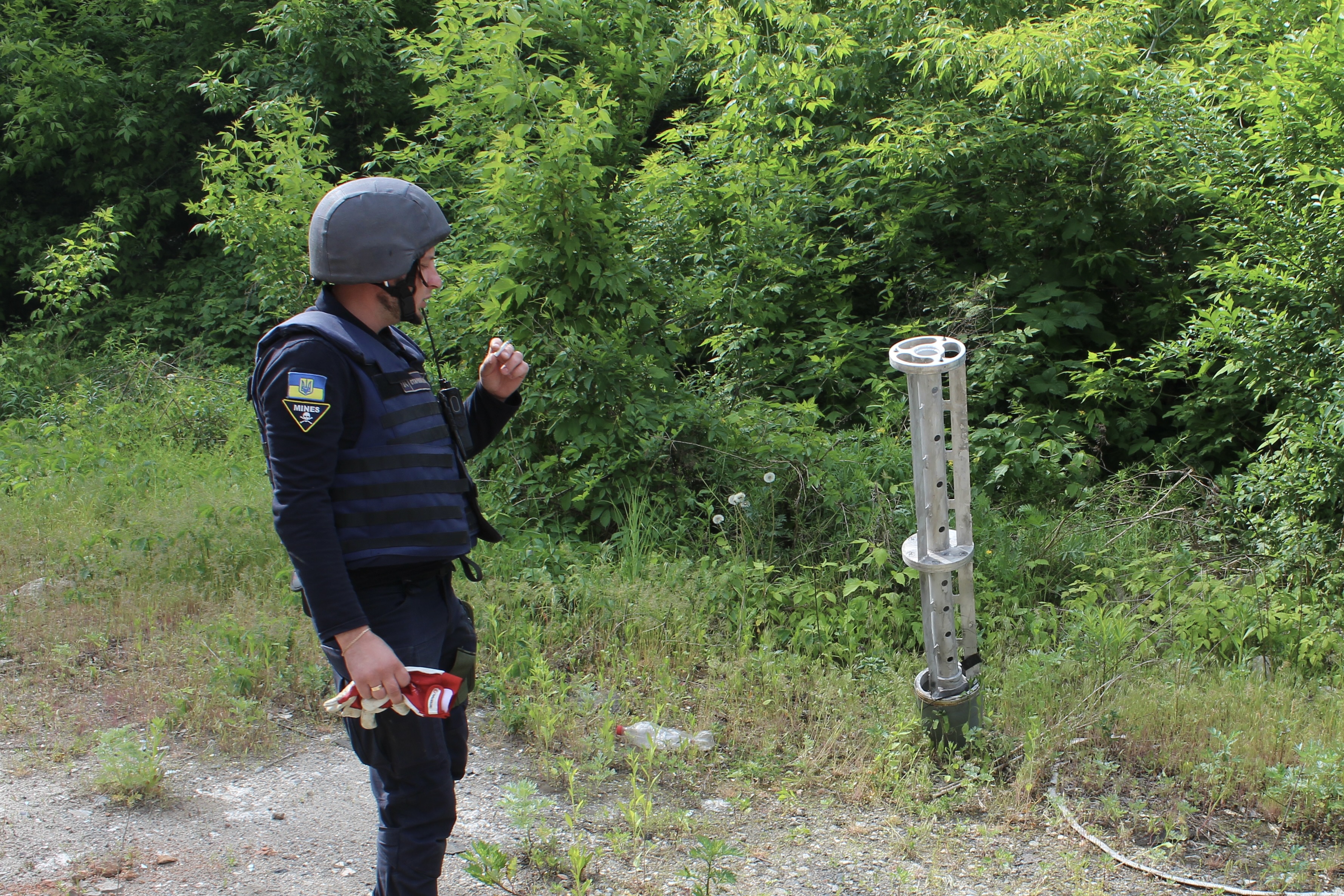 Emergency worker examines Russian Uragan cluster bomb rocket that landed in Kharkiv, Ukraine, May 21, 2022.