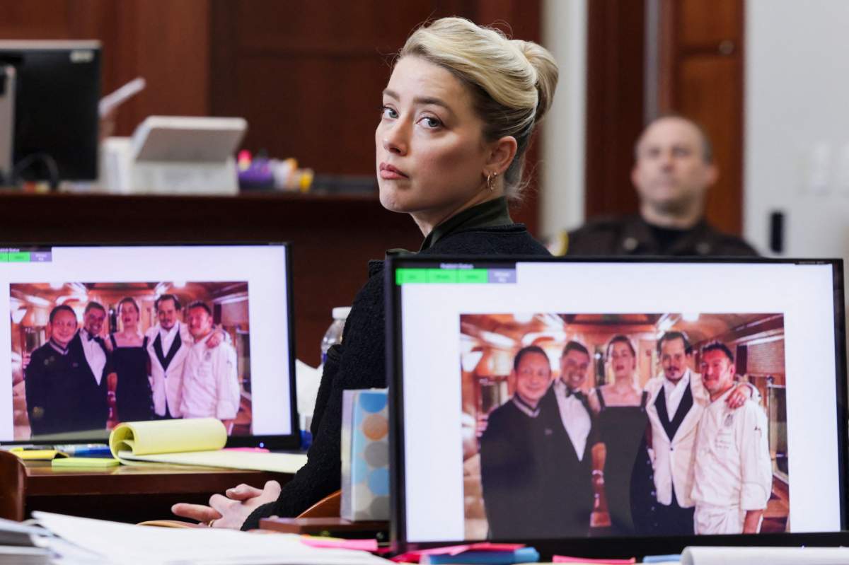 A picture introduced into evidence of actor Johnny Depp and his ex-wife actor Amber Heard with the staff of the Orient Express train taken at the end of their honeymoon trip in Singapore after their wedding in 2015, is displayed on the screens during Depp's defamation trial against his ex-wife Amber Heard, at the Fairfax County Circuit Courthouse in Fairfax, Virginia, on May 25, 2022.