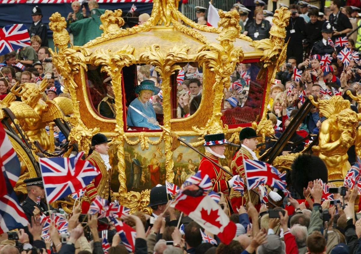 Queen Elizabeth (R) and Prince Philip ride in the Golden State Carriage at the head of a parade from Buckingham Palace to St Paul's Cathedral celebrating the Queen's Golden Jubilee June 4, 2002 in this file photo.