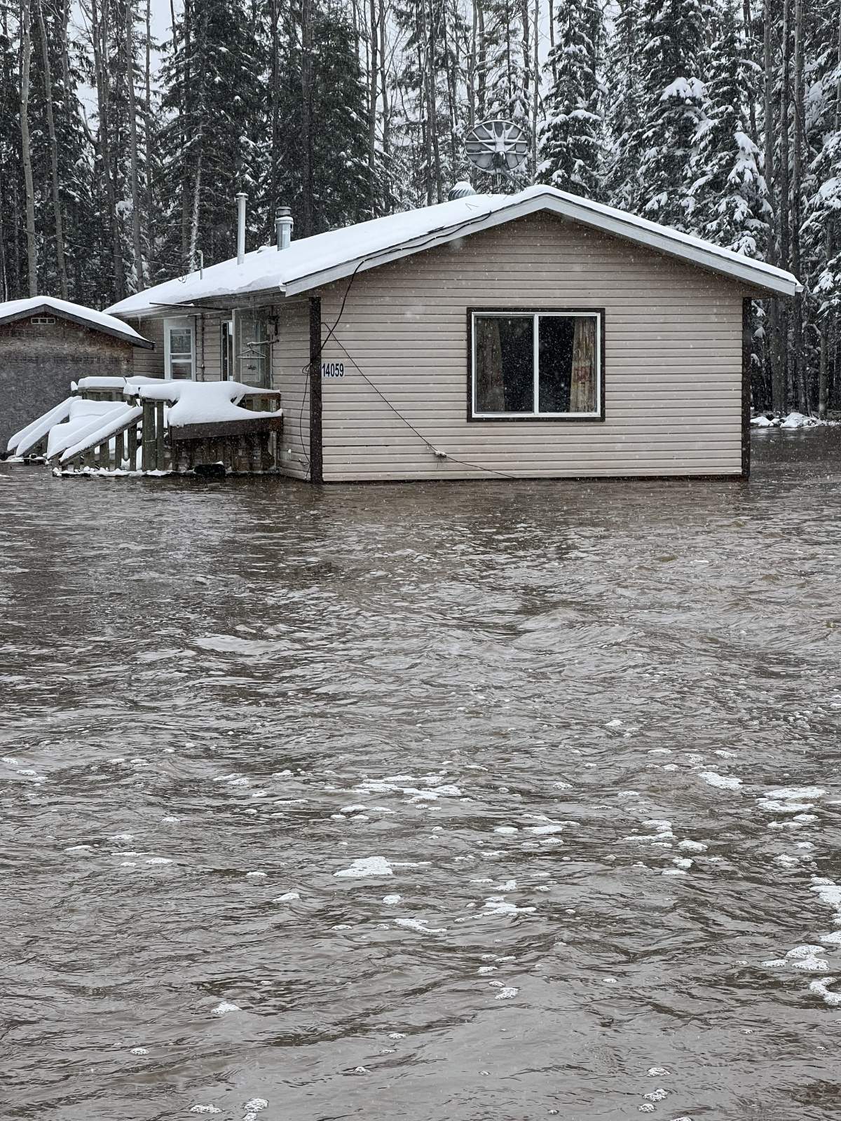 Flood waters surrounding a home in Chateh, on the Dene Tha' First Nation, in northwestern Alberta on Tuesday. May 10, 2022.