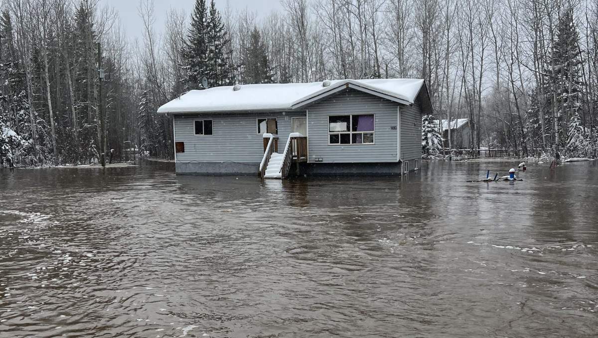 Flood waters surrounding a home in Chateh, on the Dene Tha' First Nation, in northwestern Alberta on Tuesday. May 10, 2022.