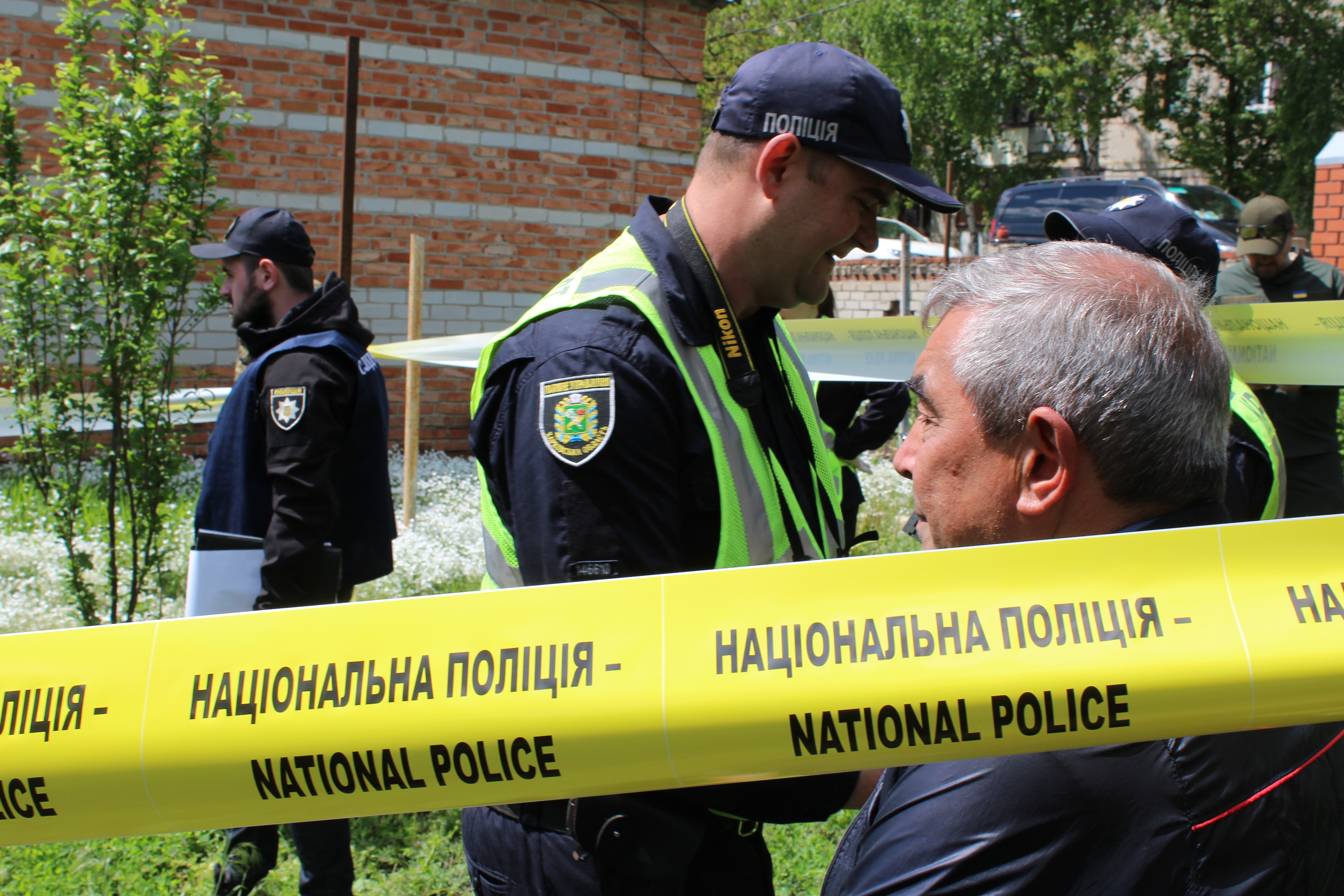 Owner of property in Mala Rohan, Ukraine, watches as war crimes investigators dig up man killed by Russian forces and buried in yard.