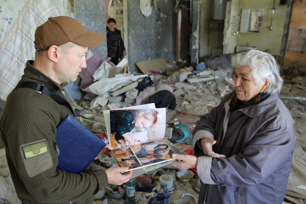 War crimes prosecutor speaks to witness of Russian air strike that destroyed residential building in Kharkiv, May 24, 2022.