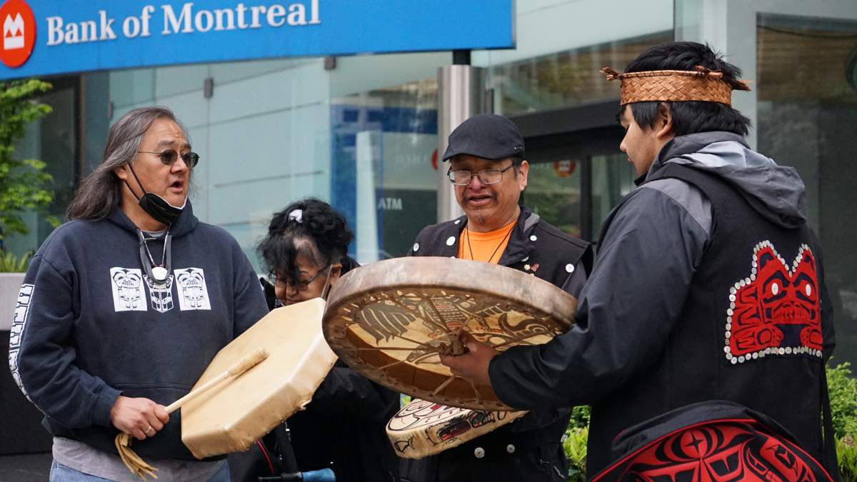 Maxwell Johnson (left) joins other Heiltsuk First Nation members in ceremony outside the Burrard Street BMO branch in Vancouver on May 5, 2022, where he announced a historic settlement with the bank.