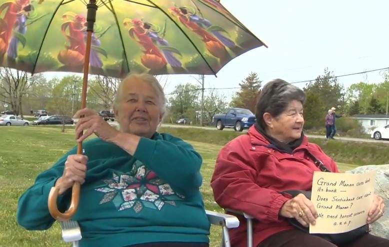 Anneke Gichuru is seen sitting with her friend near the Grand Manan Scotiabank protest.