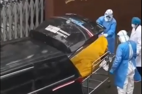 Workers in Shanghai unzip a yellow body bag on a stretcher to discover that the elderly patient inside is still alive.