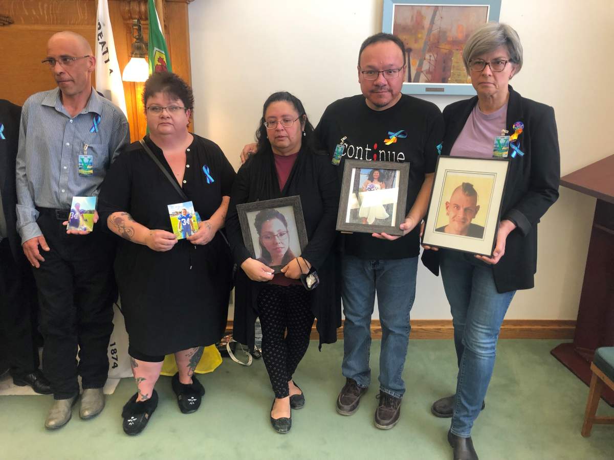 Family members display photos of loved ones lost to suicide at the Saskatchewan legislative building.