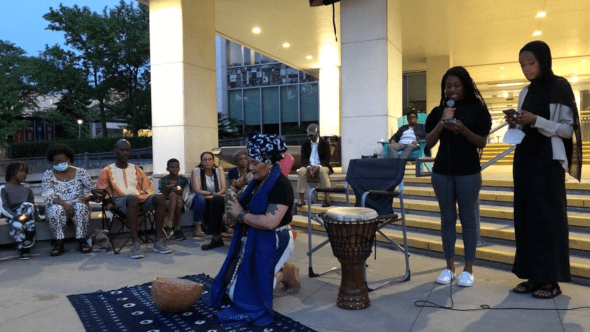 Musician Mosa McNeilly poured libations at a vigil in front of Hamilton City Hall on Monday in memory of the victims of the Buffalo massacre and those affected by white supremacist violence.