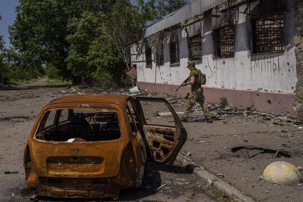 A Ukrainian serviceman patrols a village near the frontline in the Donetsk oblast region, eastern Ukraine, Thursday, June 2, 2022. (AP Photo/Bernat Armangue).