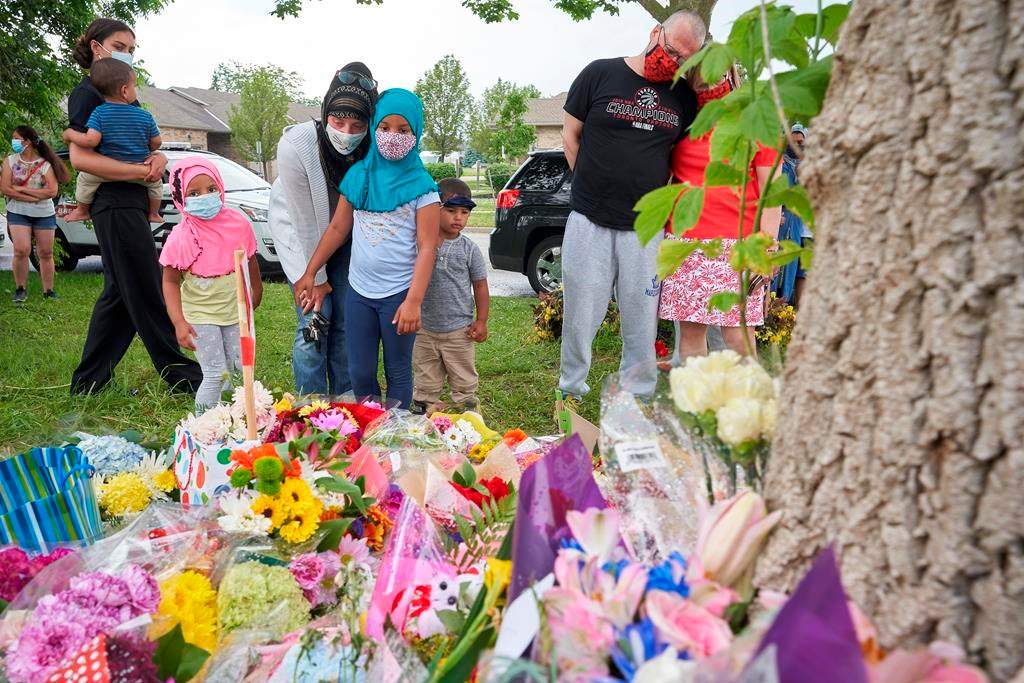 Mourners visit the scene of a hate-motivated vehicle attack in London, Ont., on June 8, 2021. The June 6, 2021, attack left four members of a family dead and their nine-year-old son in hospital. THE CANADIAN PRESS/ Geoff Robins.