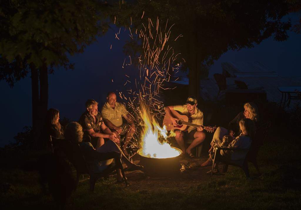  A family enjoys a camp fire by the lake. An open fire ban in forests in the southern half of Quebec was lifted on Monday, July 17, 2023. 