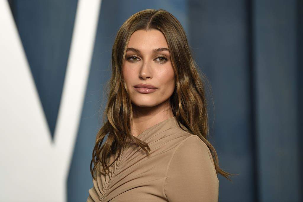Hailey Bieber in a brown dress arrives at the Vanity Fair Oscar Party on March 27, 2022, at the Wallis Annenberg Center for the Performing Arts in Beverly Hills, Calif.