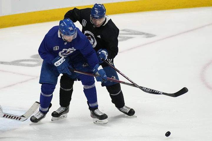 Colorado Avalanche right wing Mikko Rantanen (96) and defenceman Jack Johnson (3) battle for the puck during an NHL hockey practice, ahead of Game 2 of the Stanley Cup Finals, Friday, June 17, 2022, in Denver. (AP Photo/John Locher)