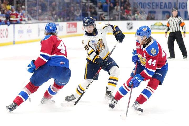 Shawinigan Cataractes’ Xavier Bourgault, centre, tries to make a move between Edmonton Oil Kings’ Kaiden Guhle, left, and Carter Souch during the second period of Memorial Cup hockey action in Saint John, N.B. on Tuesday, June 21, 2022.