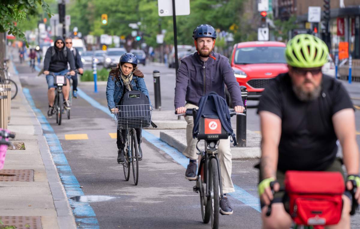 Cyclists make their way down the REV, Reseau Express Velo, on St-Denis street during the morning commute in Montreal on Thursday, June 2, 2022.