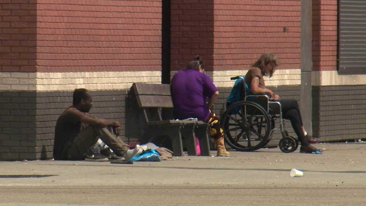 People sitting outside the Hope Mission homeless shelter in central Edmonton on June 13, 2022.