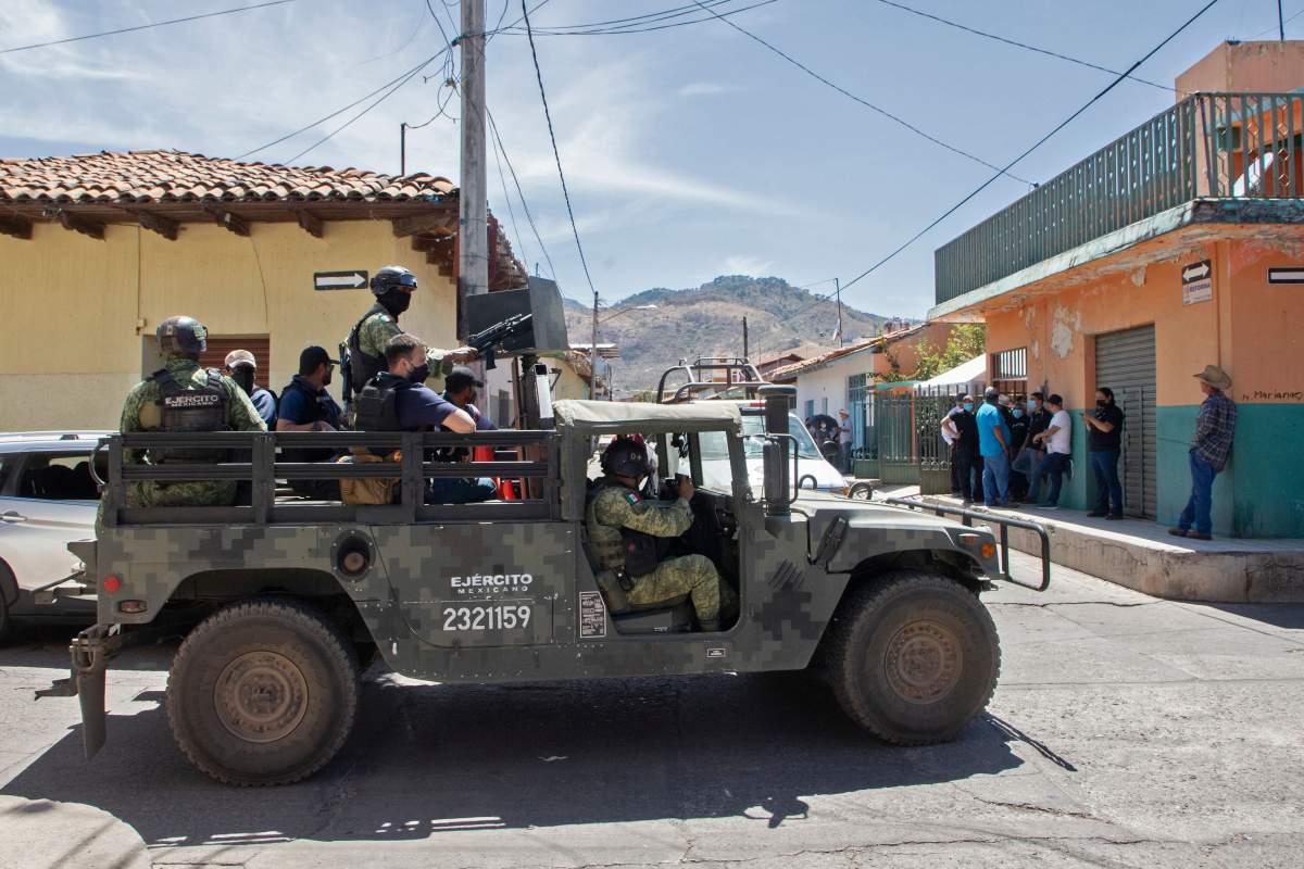 Soldiers patrol the streets during the funeral of Mayor Cesar Arturo Valencia, in Aguililla, Michoacán state, Mexico, on March 11, 2022.