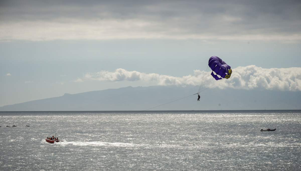 Holiday makers parasail off Los Cristianos on the southern coastline of Spain's Canary island of Tenerife on July 10, 2017.