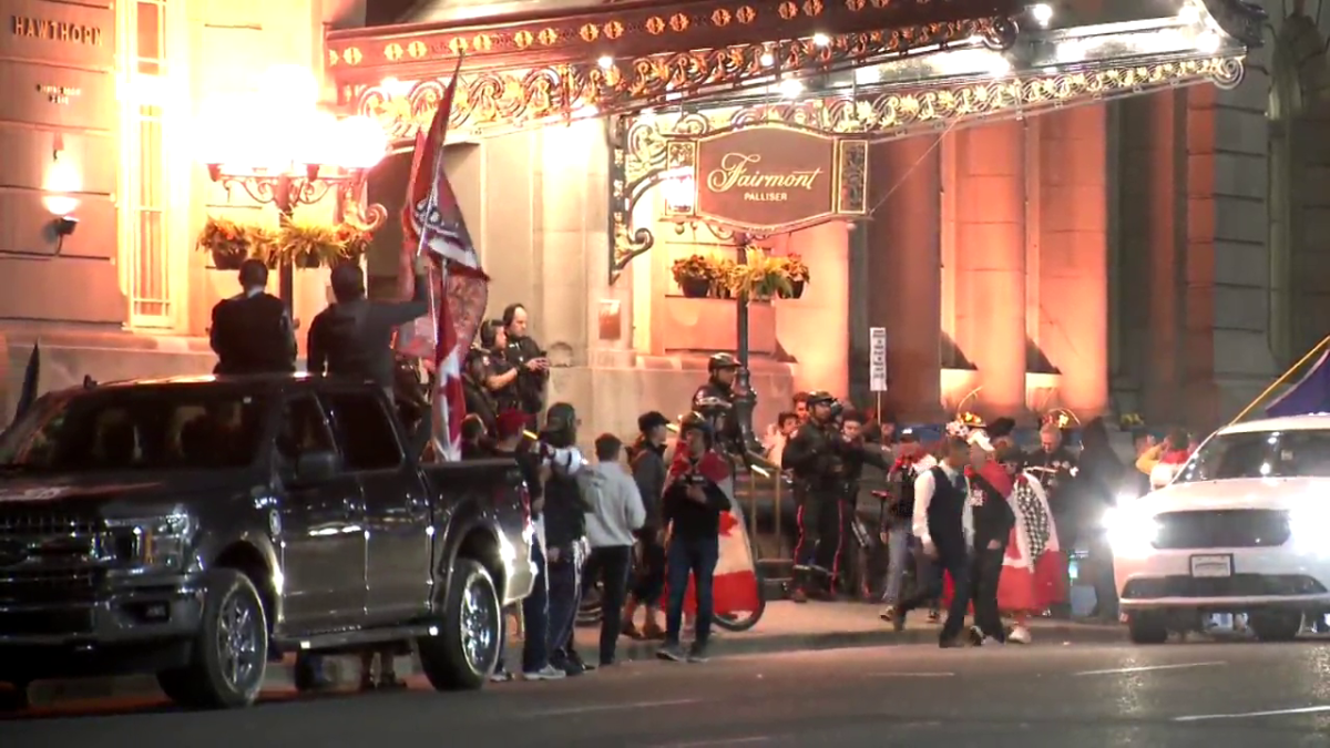 Protesters gather outside the Fairmont Palliser hotel in Calgary Wednesday, June 1, 2022.