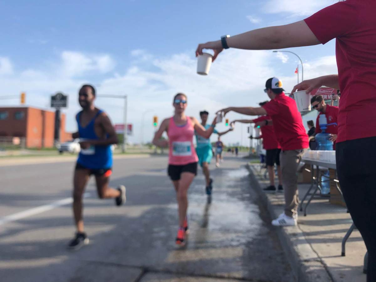 Runners grab water at the Manitoba Marathon on June 19, 2022./Arsalan Saeed