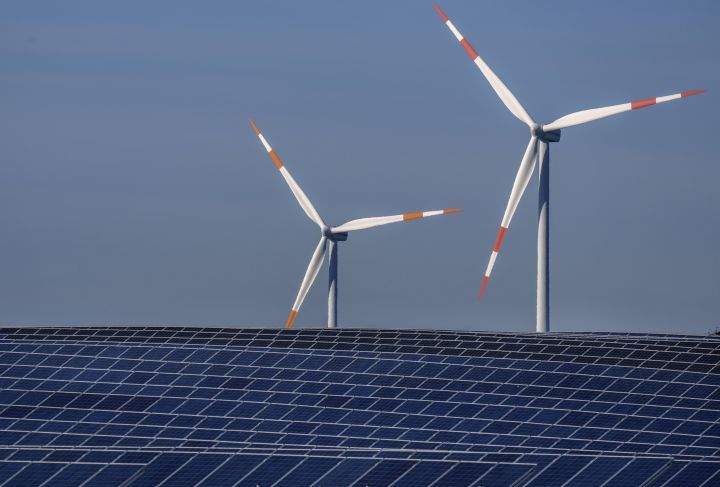 FILE -- Wind turbines turn behind a solar farm in Rapshagen, Germany, Thursday, Oct. 28, 2021. 